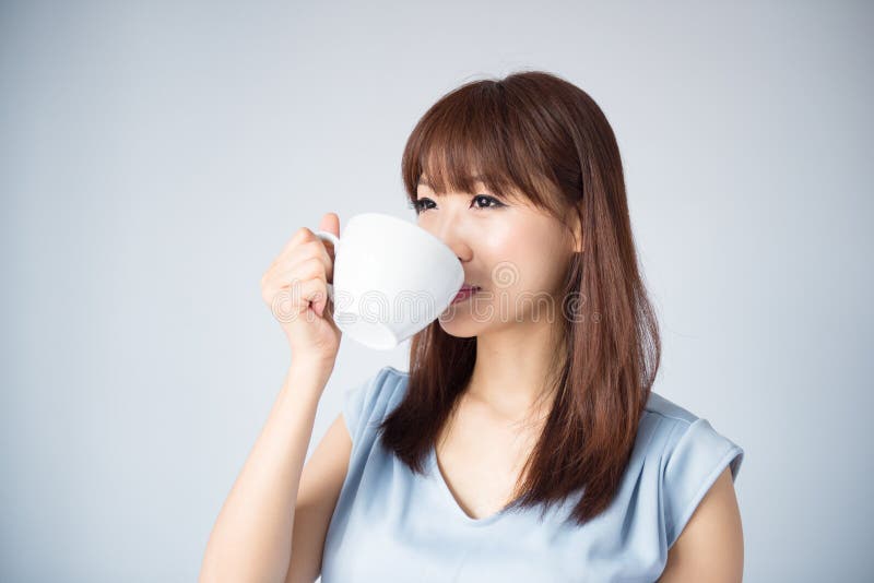 Asiatisk kvinna som dricker en kopp kaffe
