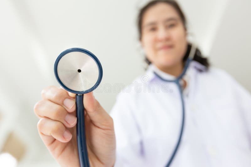 Asiatisk kvinnlig innehavstetoskop för medicinsk doktor, ung sjuksköterska som kontrollerar patienten som använder stetoskopet, a royaltyfri foto Asiatisk kvinnlig innehavstetoskop för medicinsk doktor, ung sjuksköterska som kontrollerar patienten som använder stetoskopet, a royaltyfri foto