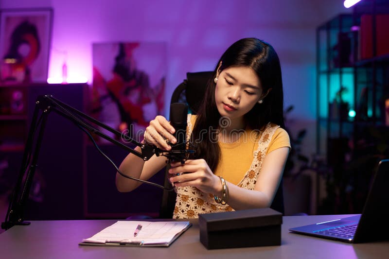 Asiatisk kvinnlig justeringsmikrofon i Home Recording Studio arkivfoton