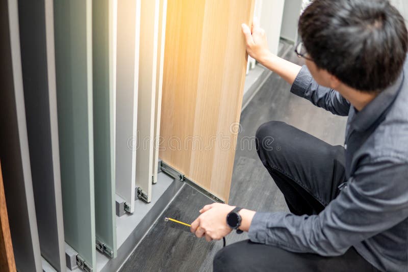 Asiatisk man som väljer kabinett- eller countertopmaterial royaltyfria bilder Asiatisk man som väljer kabinett- eller countertopmaterial royaltyfria bilder