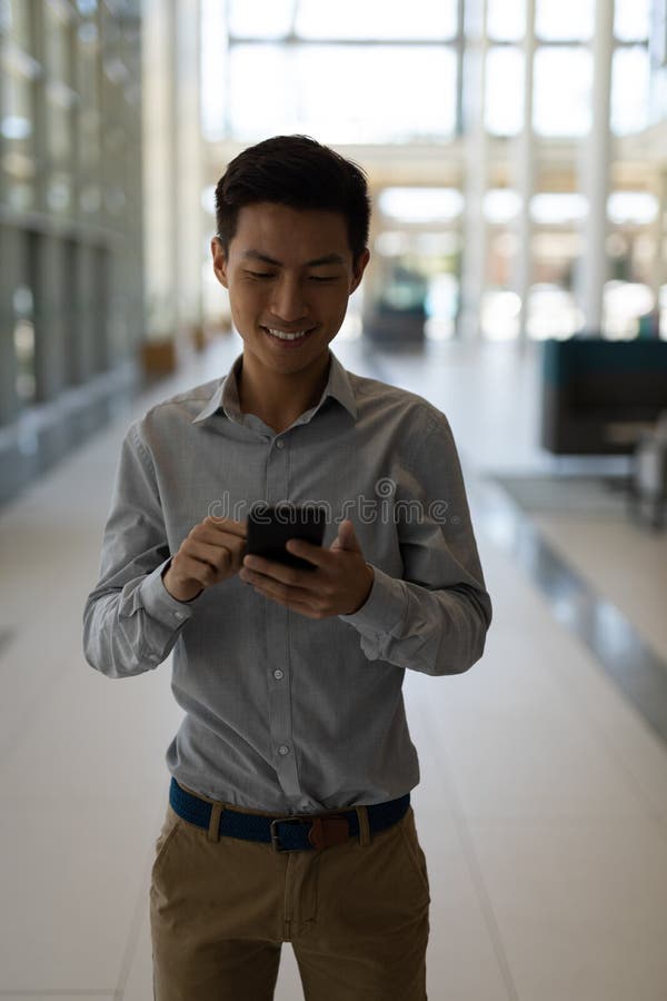 Asiatisk manlig ledare som använder mobiltelefonen i modernt kontor royaltyfri fotografi Asiatisk manlig ledare som använder mobiltelefonen i modernt kontor royaltyfri fotografi