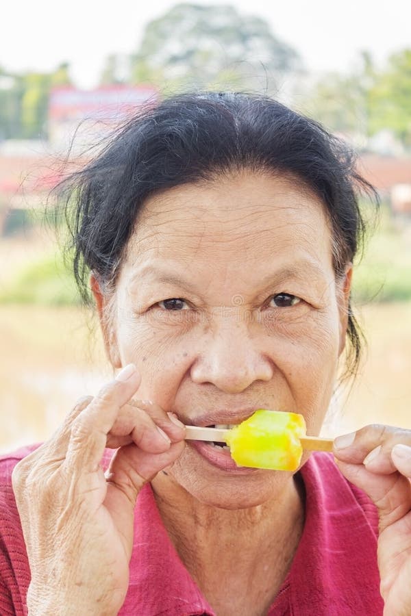 Asiatisk thailändsk kvinna som äter glass arkivfoto Asiatisk thailändsk kvinna som äter glass arkivfoto