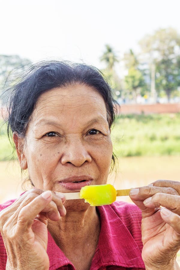 Asiatisk thailändsk kvinna som äter glass fotografering för bildbyråer Asiatisk thailändsk kvinna som äter glass fotografering för bildbyråer