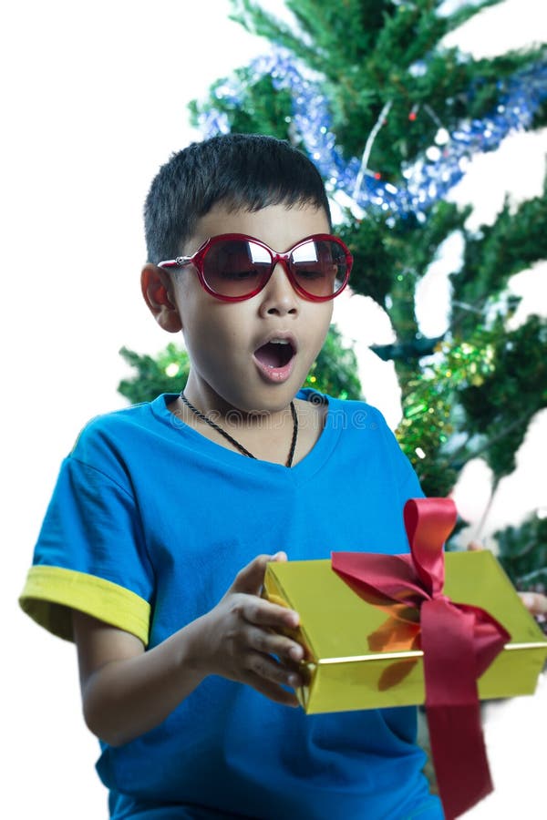 Asiatisk unge på solglasögonöverraskningen som får julklapp arkivfoton Asiatisk unge på solglasögonöverraskningen som får julklapp arkivfoton