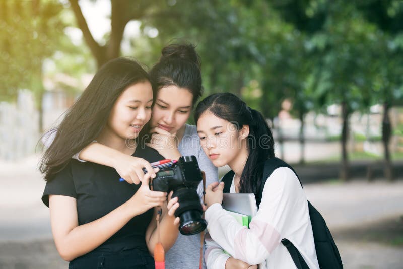 Asiatiska kvinnagruppturister som ser kamera` s, övervakar att kontrollera royaltyfri fotografi Asiatiska kvinnagruppturister som ser kamera` s, övervakar att kontrollera royaltyfri fotografi