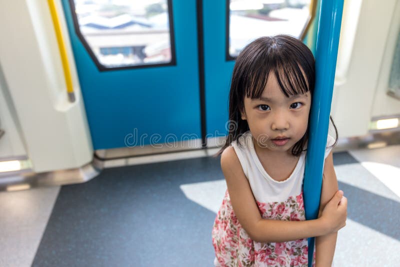 Asiatiskt kinesiskt liten flickaanseende inom en MRT-transport royaltyfri foto Asiatiskt kinesiskt liten flickaanseende inom en MRT-transport royaltyfri foto