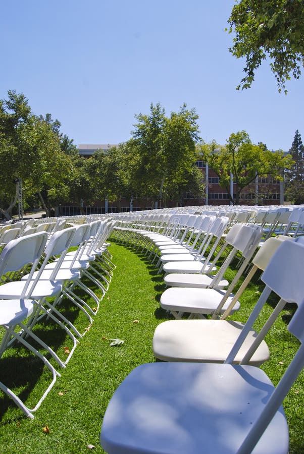 Rows of white folding chairs. Rows of white folding chairs.