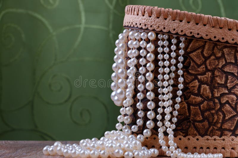 Birch bark box with pearl beads on green fabric background. Birch bark box with pearl beads on green fabric background