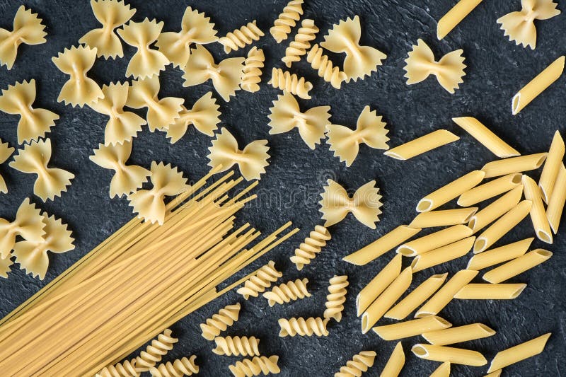 Asortowany Uncooked makaron. Asortowany uncooked surowy makaron na czarnym tle Włoski makaron: penne, farfalle, spaghetti, fusilli