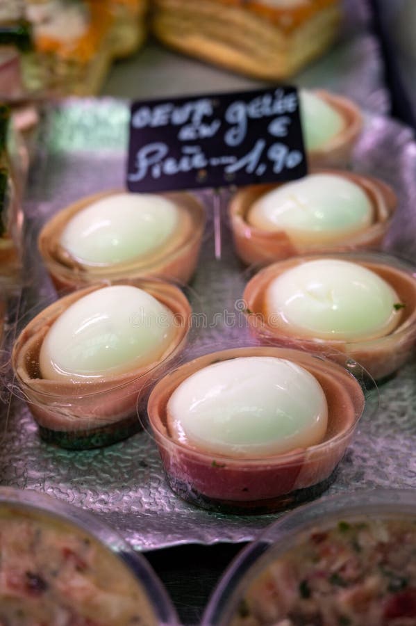 Assortment of meat on weekly food market in France, English translation: chicken eggs in jelly price of 1 piece. Assortment of meat on weekly food market in France, English translation: chicken eggs in jelly price of 1 piece