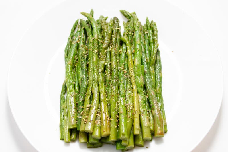 Asparagus med vitlök på en vit platta royaltyfri fotografi Asparagus med vitlök på en vit platta royaltyfri fotografi