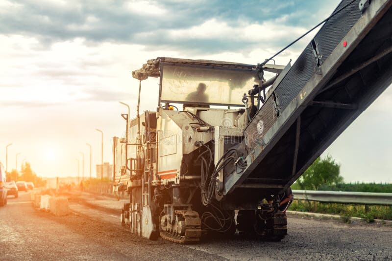 Asphalt milling and grinding machine at road repair and construction site. Highway renewal with heavy machinery royalty free stock images Asphalt milling and grinding machine at road repair and construction site. Highway renewal with heavy machinery royalty free stock images