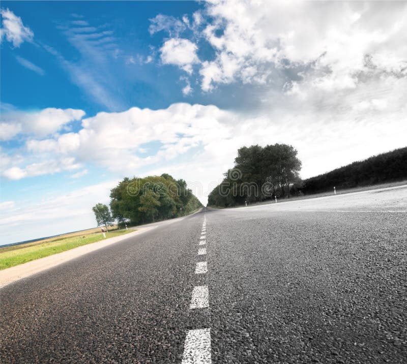 Asphalt road in green meadow