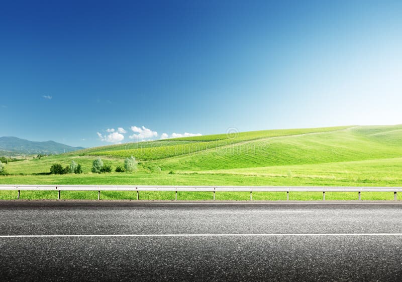 Strada asfaltata e perfetto campo verde.