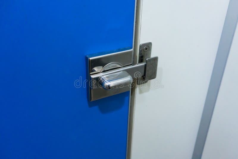 Asphaltieren Sie Verschlussklinke für Verschluss die Toilettenblautür. Asphaltieren Sie Verschlussklinke für Verschluss die blaue Tür der Toilette in der öffentlichen Toilette