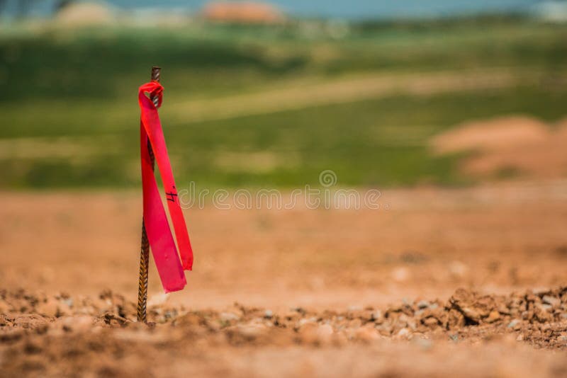 Asphaltieren Sie Übersichtsklammer mit roter Fahne auf Baustelle stockbild Asphaltieren Sie Übersichtsklammer mit roter Fahne auf Baustelle stockbild