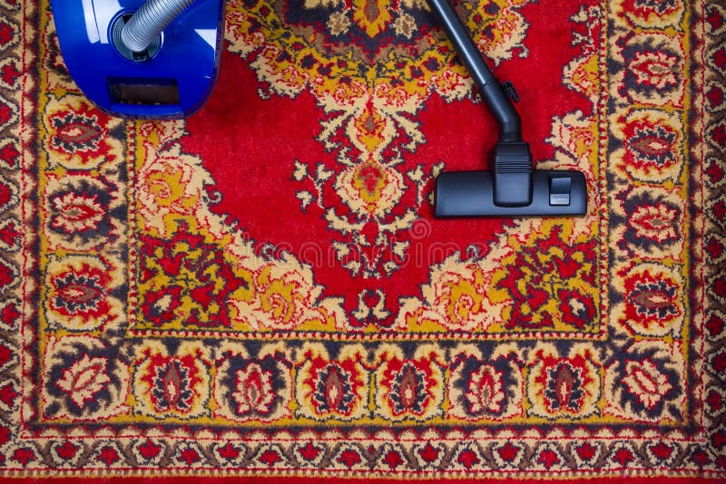 Aspirateur électrique sur le fond d'un vieux tapis, vue supérieure photo libre de droits Aspirateur électrique sur le fond d'un vieux tapis, vue supérieure photo libre de droits