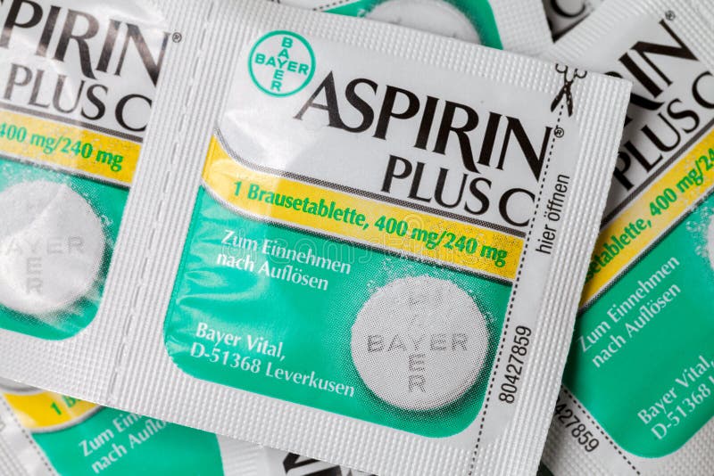 Aspirin plus C headache pills lies on brown background.