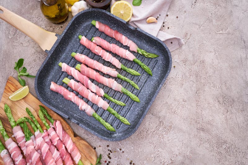 Aspárragos cocinados con tocino en una sartén frita a la parrilla.