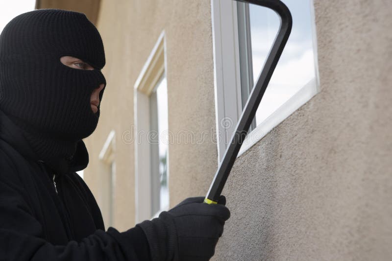 Assaltante Breaking Into House foto de stock Assaltante Breaking Into House foto de stock
