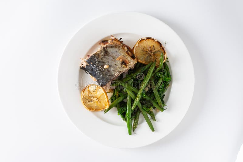 Assaporare i sapori sani di fagioli verdi al forno con cipolle e sgombro arrotolato elegantemente su fondo bianco fotografia stock libera da diritti