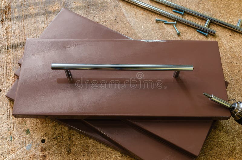 Assemblerend meubilair, die meubilair decoratieve handvatten installeren op de meubilairvoorgevel stock foto Assemblerend meubilair, die meubilair decoratieve handvatten installeren op de meubilairvoorgevel stock foto