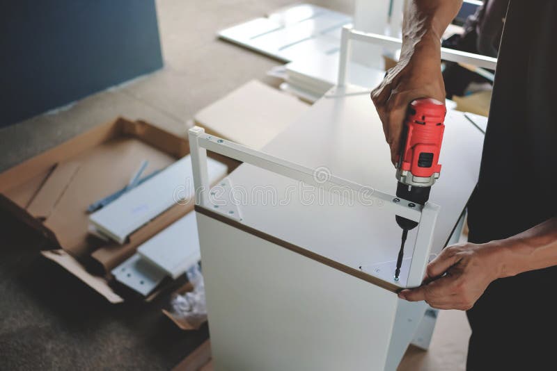 Assembling Furniture at Home. Moving for a New House or DIY Concept. Craftsman using Cordless Screwdriver stock photos