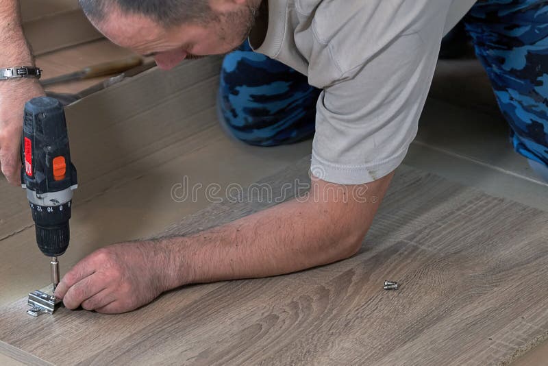Assembling Furniture, the Master with the Tool Sets the Hardware Stock