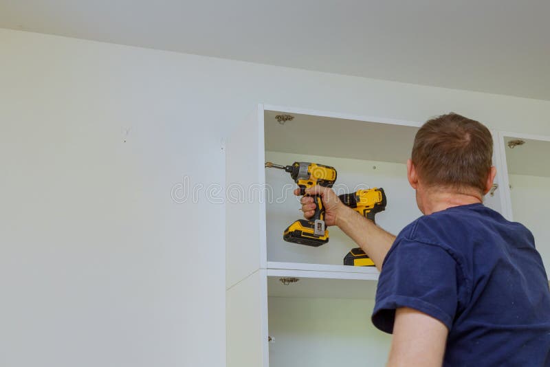 Assembling new custom kitchen in various stages of installation wall cabinets