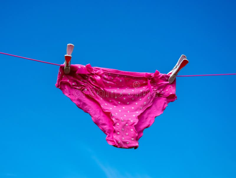 Assez dans des culottes roses séchant sur la ligne de lavage images stock Assez dans des culottes roses séchant sur la ligne de lavage images stock
