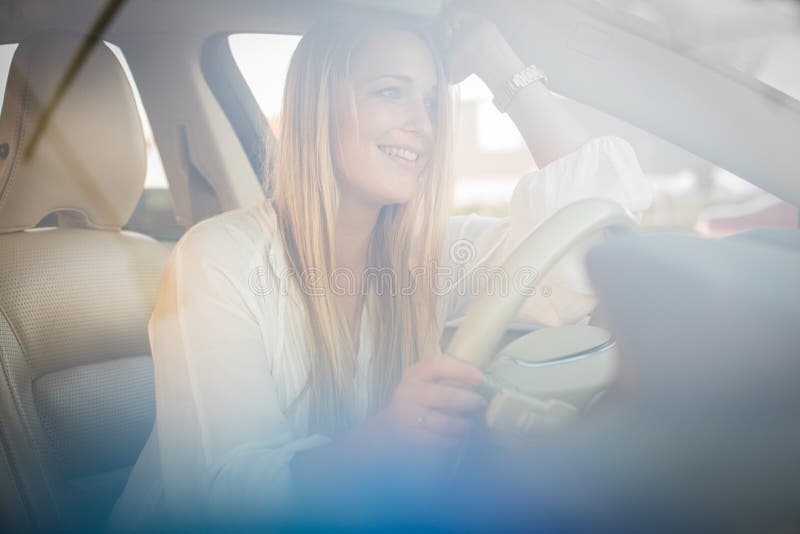 Assez, jeune femme conduisant une voiture image stock Assez, jeune femme conduisant une voiture image stock