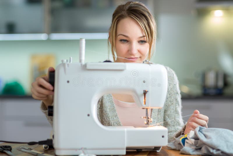 Assez, vêtements de couture de jeune femme avec la machine à coudre images stock Assez, vêtements de couture de jeune femme avec la machine à coudre images stock