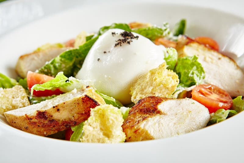 Assiette de restaurant blanc de salade de césar avec poulet anchois maison sauces croutons tomates greens fermer. photos stock