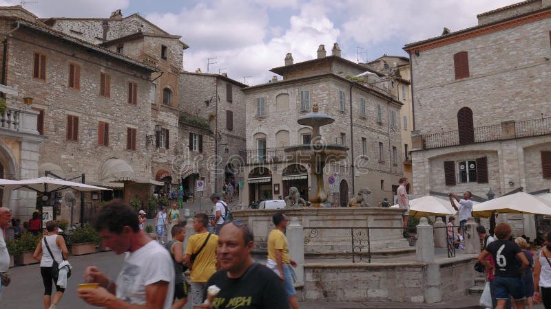 Assisi springbrunn och medeltida hus, Umbria, Italien