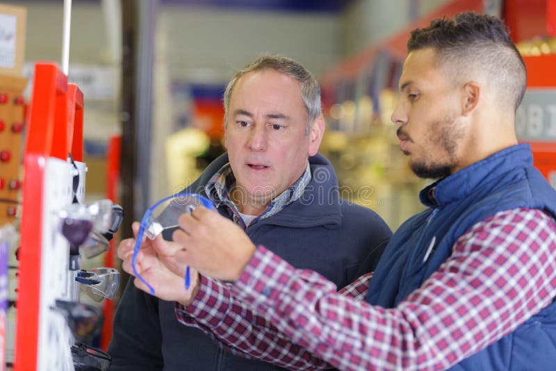 Assistente com cliente numa loja de ferragens de auto-serviço fotografia de stock
