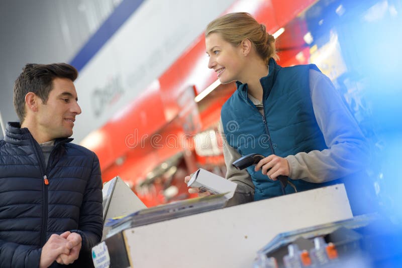 Assistente de vendedora positiva em loja de supermercados de hardware fotografia de stock