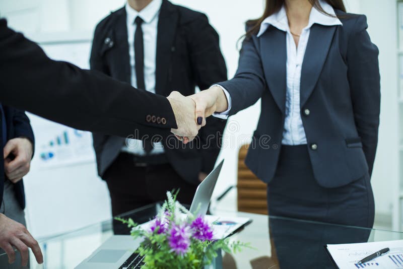 Associés de poignée de main après l'examen du contrat au lieu de travail image stock Associés de poignée de main après l'examen du contrat au lieu de travail image stock