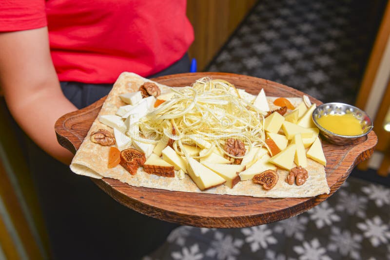 Assorted Cheeses in Various Shapes and Sizes. Waiter Serving Cheese