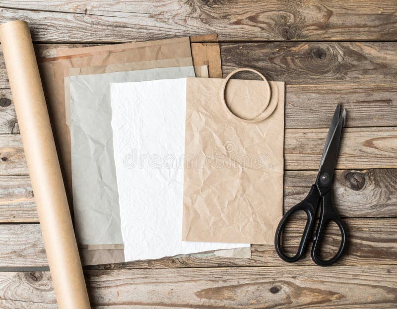 Assorted Craft Paper and Scissors on Weathered Wood Surface in Warm Tone royalty free illustration