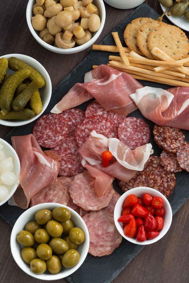 Assorted Deli Meat Snacks, Sausages and Pickles on Board Stock Photo