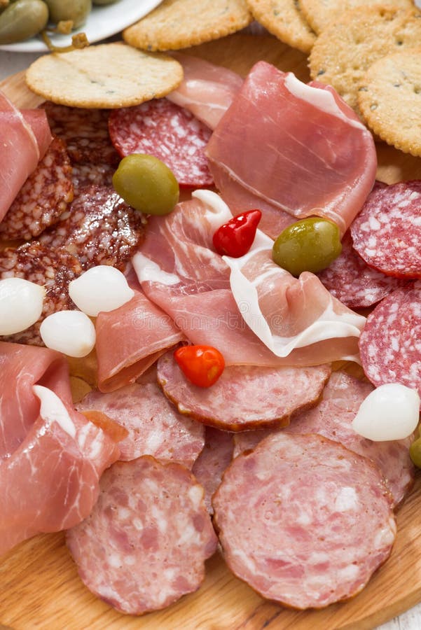 Assorted Deli Meat Snacks, Sausages and Pickles on Board Stock Photo
