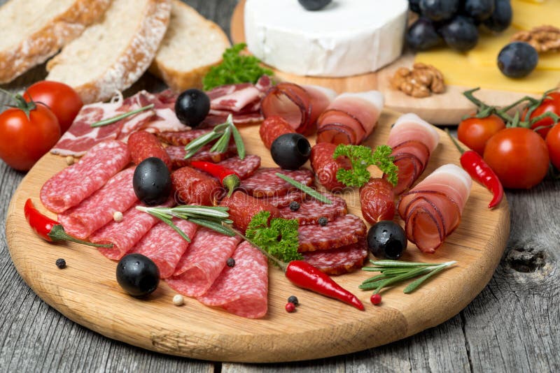 Assorted meats and sausages on a wooden board