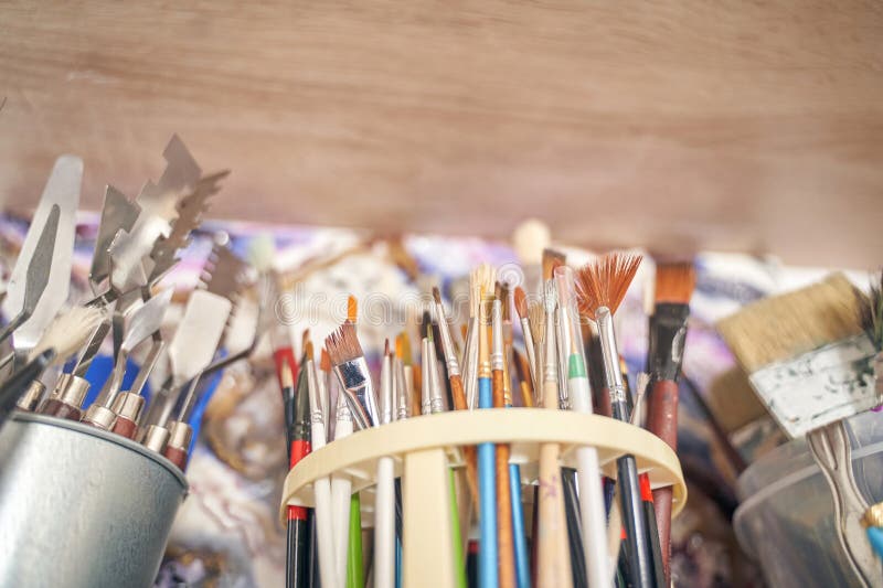 Assorted paint brushes and art tools in studio setting for creative painting royalty free stock images