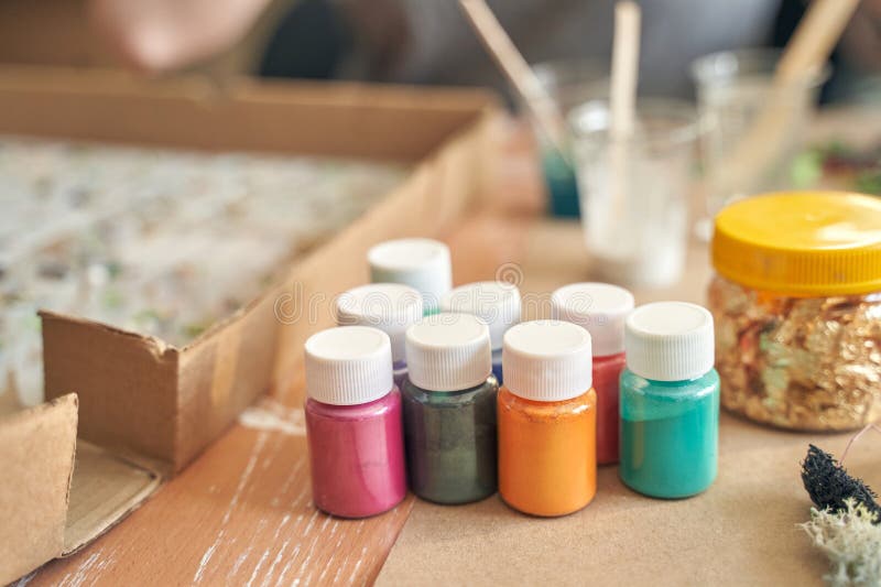 Assorted paint jars and craft materials on table for creative art projects stock images