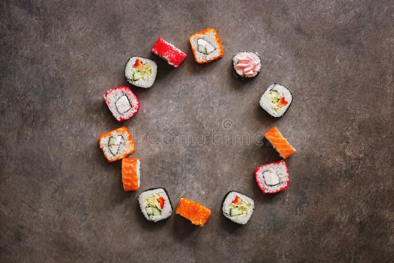 Assorted sushi roll round frame on a dark rustic background. Traditional japanese food. Top view, flat lay, copy space stock images Assorted sushi roll round frame on a dark rustic background. Traditional japanese food. Top view, flat lay, copy space stock images