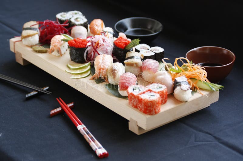 Assorted Types of Sushi on Bamboo Table with Hashi Chopsticks and Shoyu