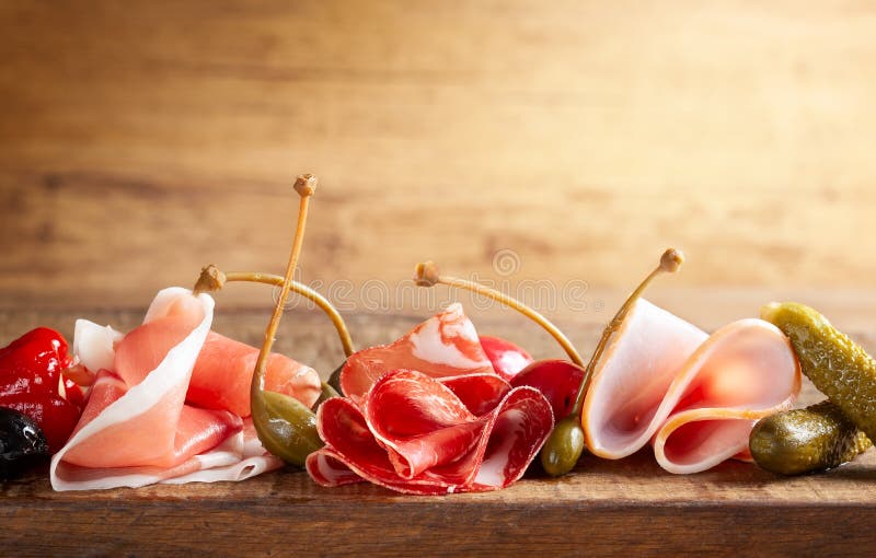 Assorti of sliced jamon, salami, ham with olives ,capers, pickles and stuffed red peppers
