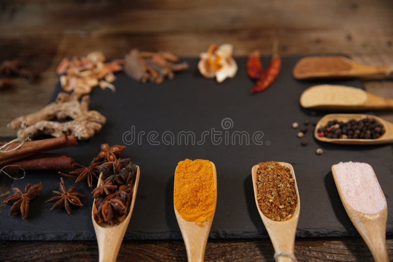 Assortiment d'épices : safran des indes, gingembre, cannelle, noix de muscade, poivre, sel rose, anis d'étoile dans des cuillères image stock Assortiment d'épices : safran des indes, gingembre, cannelle, noix de muscade, poivre, sel rose, anis d'étoile dans des cuillères image stock