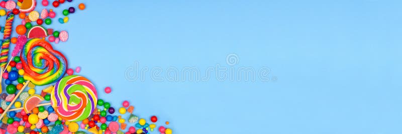 Assortimento colorato di caramelle al di sopra del bordo angolo della vista con uno sfondo blu banner fotografie stock