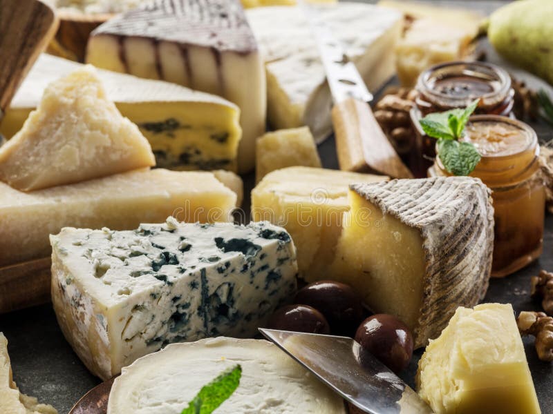 Assortimento di formaggi diversi con olive e confetture. fondo alimentare immagine stock
